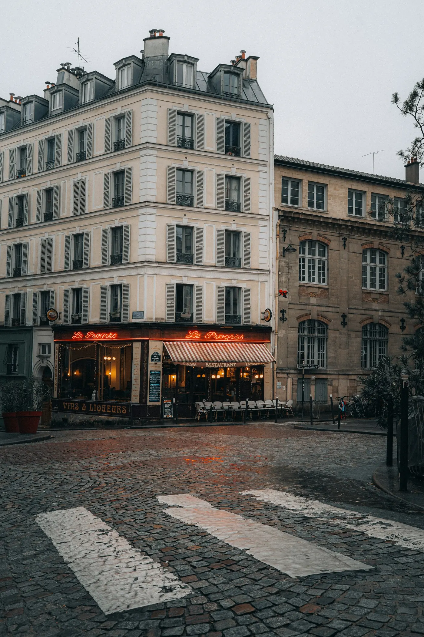 Terrasse de café et rue pavée à Paris, à l'heure bleue